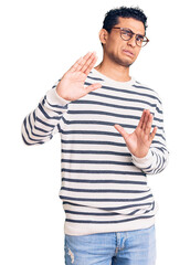 Sticker - Hispanic handsome young man wearing casual clothes and glasses disgusted expression, displeased and fearful doing disgust face because aversion reaction. with hands raised