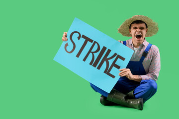 Wall Mural - Protesting male farmer holding placard with word STRIKE on green background