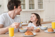 © InsideCreativeHouse - Lovely cheerful young father dad looking at his little daughter sitting in the kitchen having breakfast together. Parenthood, fatherhood. Happy father`s day! I love you, dad!