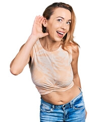 Poster - Young caucasian woman wearing casual style with sleeveless shirt smiling with hand over ear listening and hearing to rumor or gossip. deafness concept.