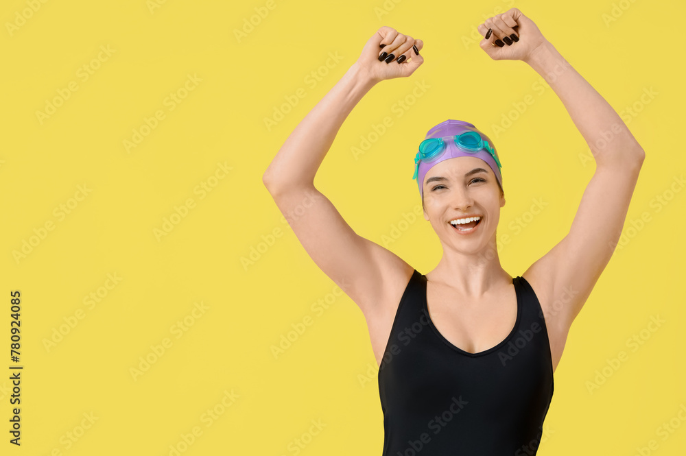 Happy female swimmer on yellow background