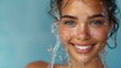 An attractive woman wearing a spa robe and splashing water over blue background. Skin care, cleansing and moisturizing concept. Beautiful face.
