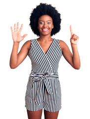 Sticker - Young african american woman wearing casual clothes showing and pointing up with fingers number six while smiling confident and happy.