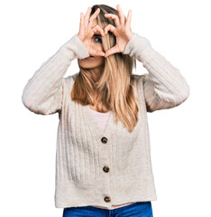 Wall Mural - Young blonde woman wearing casual clothes doing heart shape with hand and fingers smiling looking through sign