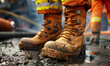 A close-up of well-worn work boots covered in mud, highlighting the tough conditions on a construction site.