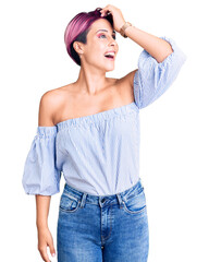 Wall Mural - Young beautiful woman with pink hair wearing casual clothes smiling confident touching hair with hand up gesture, posing attractive and fashionable