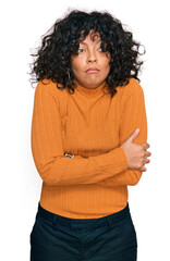 Poster - Young hispanic woman wearing casual clothes shaking and freezing for winter cold with sad and shock expression on face