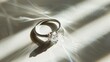 © Orxan - A white gold ring, specifically a silver ring with a diamond, is showcased on a white background with shadows, presenting a still life and creative photograph