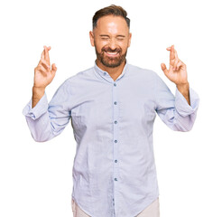 Poster - Handsome middle age man wearing business shirt gesturing finger crossed smiling with hope and eyes closed. luck and superstitious concept.