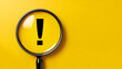 © Loliruri - Attention sign,Exclamation mark,warning sign concept.,Magnifying glass focus on Hazard warning attention sign icon over yellow background with copy space