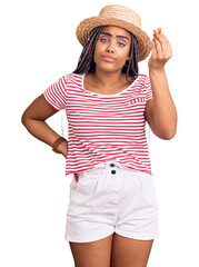 Wall Mural - Young african american woman with braids wearing summer hat doing italian gesture with hand and fingers confident expression