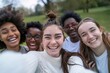 Multiracial group of collage friends taking big group selfie shot smiling at camera - Laughing young people standing outdoor and having fun - Cheerful students portrait outside school