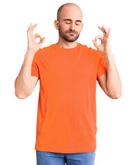 Wall Mural - Young handsome man wering casual t shirt relax and smiling with eyes closed doing meditation gesture with fingers. yoga concept.