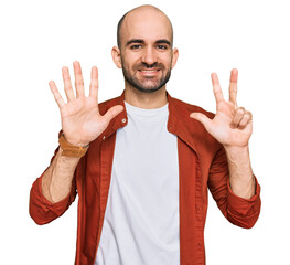 Wall Mural - Young hispanic man wearing casual clothes showing and pointing up with fingers number eight while smiling confident and happy.