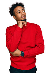 Wall Mural - Young african american man with beard wearing casual winter sweater with hand on chin thinking about question, pensive expression. smiling and thoughtful face. doubt concept.