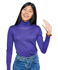 Sticker - Beautiful young asian woman wearing casual clothes waiving saying hello happy and smiling, friendly welcome gesture