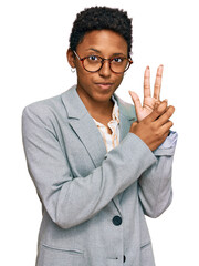 Wall Mural - Young african american woman wearing business clothes holding symbolic gun with hand gesture, playing killing shooting weapons, angry face