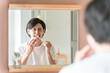 洗面所で歯を磨く若いアジア人男性（知覚過敏・歯周病・虫歯・しみる）
