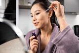 Fototapeta  - Confident Young Woman Applying Serum In Cozy Home Setting, Skincare Routine