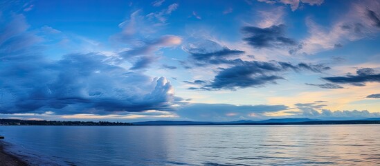 Sticker - A serene view of a beach featuring a solitary bench by the water's edge, creating a tranquil and scenic setting