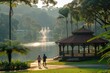 A couple jogs early in a tropical park with lush foliage and a gazebo by the lakeside.