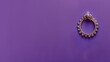 Golden earring with intricate details on purple background