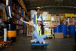 © offsuperphoto - factory workers moving cart and having fun in the warehouse storage