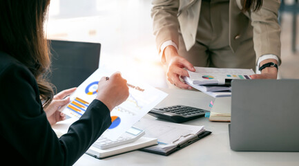 Two business people working, discussing business strategy at office desk.