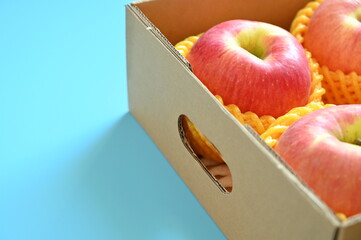 Wall Mural - beautiful pink apple in the box on blue background