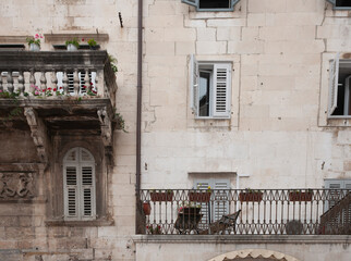 Poster - Old European exterior residential apartment building with two balcony styles and shuttered windows.