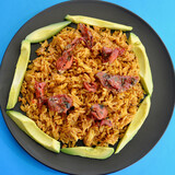 Fototapeta Uliczki - Spicy Mexican style rice with sliced avocado and sun dried tomatoes in a plate.