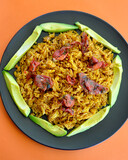 Fototapeta  - Spicy Mexican style rice with sliced avocado and sun dried tomatoes in a plate.