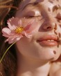 Close up portrait of fair skinned young woman with freckles on pink and yellow background with flowers near face,  summer lifestyle concept