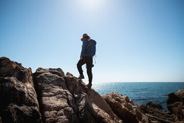 Wall Mural - Woman photographer enjoy the view on sunrise seaside rocks