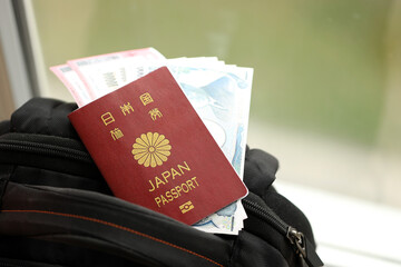 Wall Mural - Japan passport with japanese yen money bills with airline tickets on backpack close up