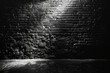 Black background with spotlight on dark brick wall, night scene. Background for product display or presentation in studio