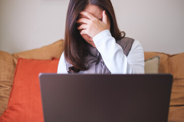 Canvas Print - A woman get headache and stressed while working online on laptop computer at home