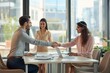 © ASDF - A group of young businesspeople are shaking hands in a meeting room