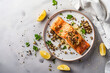 Baked salmon with quinoa on a light table, top view
