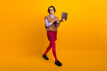 Canvas Print - Photo portrait of attractive young woman walk hold netbook ecommerce dressed retro office clothes isolated on yellow color background