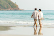 © CandyRetriever  - Happy Asian family senior couple walking together on tropical island beach at summer sunset. Retired elderly people relaxing and enjoy outdoor lifestyle travel nature ocean on holiday vacation.
