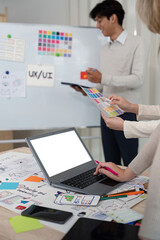 Wall Mural - designer team recommends color while mockup laptop display ui and ux designs for mobile app and webs