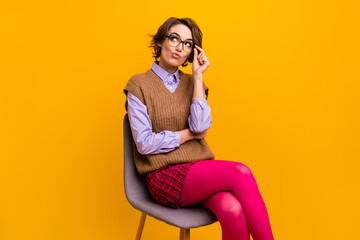 Sticker - Photo portrait of attractive woman sit chair look unsure point empty space dressed retro office clothes isolated on yellow color background