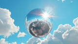 Fototapeta Natura - A 3D render of an abstract modern minimal background with white clouds, a chrome metallic mirror ball, and a blue sky with white clouds