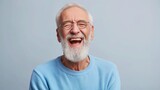 Fototapeta  - Portrait of old man wearing a blue sweater and glasses. laughing old man whit a beard, in glasses, happy against gray background.