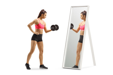 Poster - Fit young female exercising weight training with a dumbbell in front of a mirror