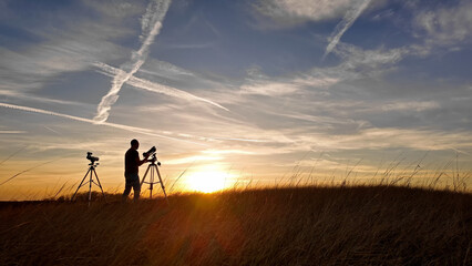 Wall Mural - amateur astronomer observing solar eclipse and sun with a telescope and special solar filter.