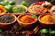 A variety of mediterranean spices and herbs in different shapes, colors and textures artfully arranged on a rustic wooden table
