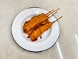 Thai style chicken satay on white dish, selective focus