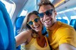 © MD Media - A happy couple taking selfie photo on airplane, Happy tourist taking selfie inside airplane - Cheerful couple on summer vacation - Passengers boarding on plane - Holidays and transportation concept